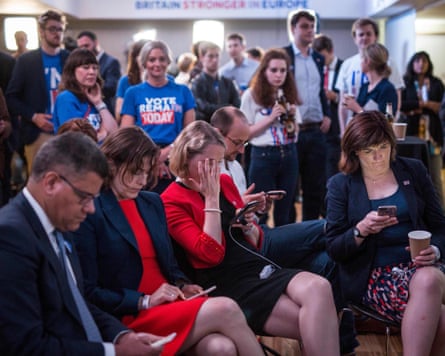 Supporters of the ‘Stronger In’ campaign look at their phones after voting closes as the results come in
