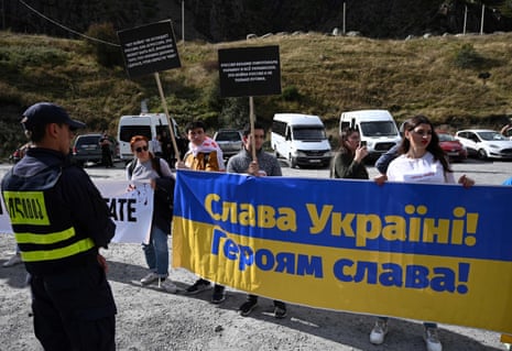 Georgian activists with a sign in Ukrainian colours which reads “Glory to Ukraine! Glory to heroes!” at the border of Georgia and Russia.