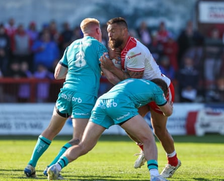 Jared Waerea-Hargreaves is tackled by Huddersfield’s Oliver Wilson and Zac Woolford