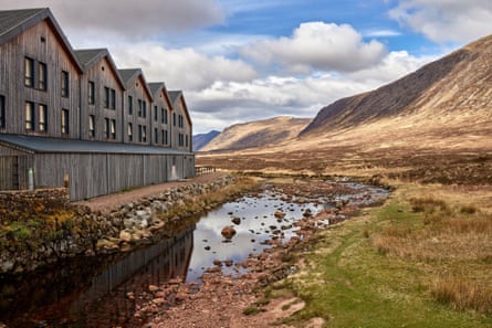 Wooden hostel on left facing hillside on right