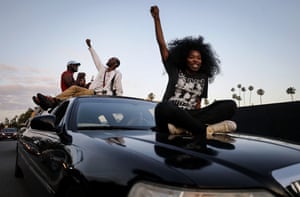 Protesters ride atop a limousine in a march toward Hollywood Boulevard during a peaceful demonstration in Los Angeles on Saturday.
