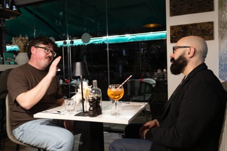 Two men facing each other across a restaurant table