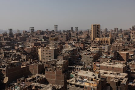 View of Manshiyet Nasr with mid-rise brown buildings under a hazy sky