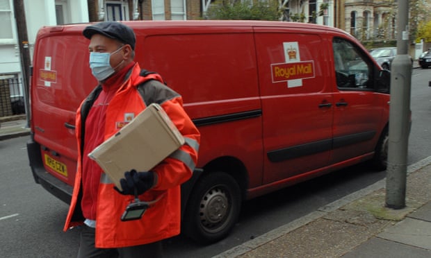 a postman wearing a mask delivers a parcel