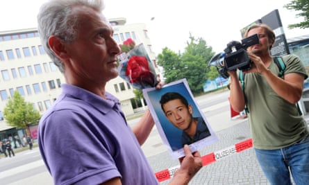 Naim Zabergja holds a photo of his son Dijamant at the Olympia shopping centre in Munich where the shooting took place