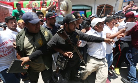 Members of the community police help to open a road as the presidential candidate Andrés Manuel López Obrador leaves a campaign rally in Guerrero state.
