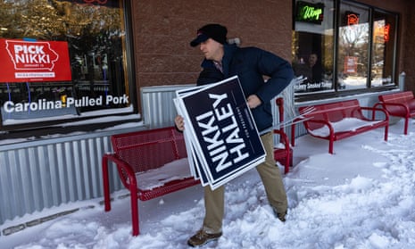 A campaign staff member for Republican presidential candidate Nikki Haley clears lawn signs following a campaign event in Ames, Iowa, on Sunday.