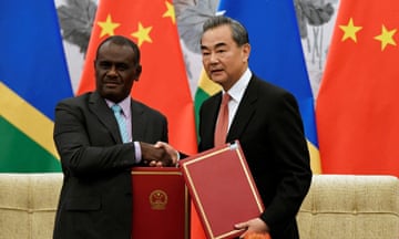 Solomon Islands Foreign Minister Jeremiah Manele (L) shakes hands with Chinese Foreign Minister Wang Yi during a ceremony to mark the establishment of diplomatic ties between the two nations at the Diaoyutai State Guesthouse in Beijing, 2019