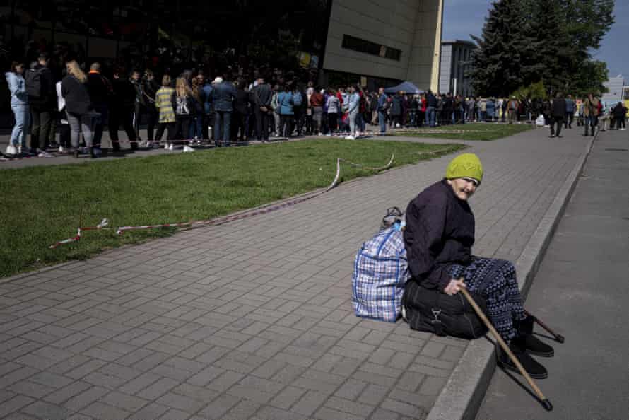 Didenko Ekaterina, 93, from the Ukrainian city of Vuhledar, waits for her daughter as people stay in line for registration at the aid distribution center for displaced people in Zaporizhia.