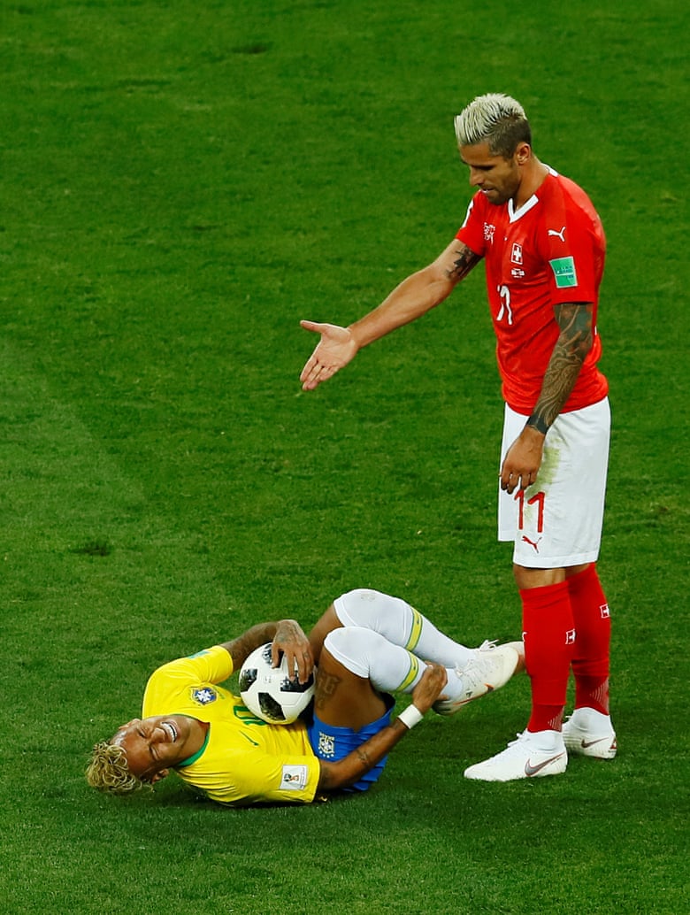Switzerland’s Valon Behrami gestures to Neymar as he rolls on the floor.