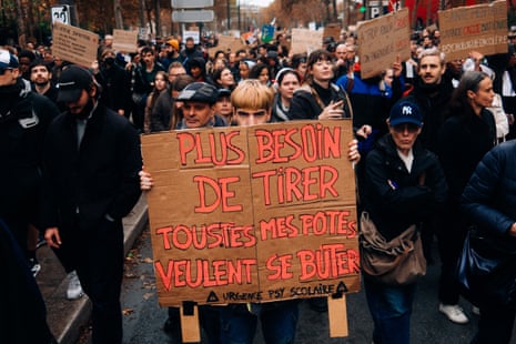 A young protester holds a placard reading "No need to shoot" during a Paris demonstration