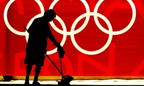 Woman sweeping the floor in front of the Olympics logo