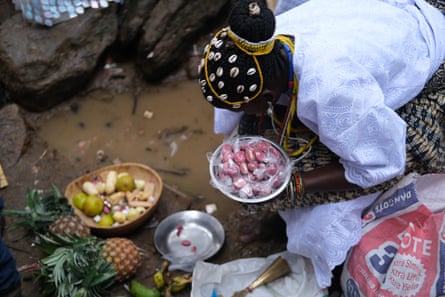 Osun priestess prepares a sacrifice to be offered to the river goddess.