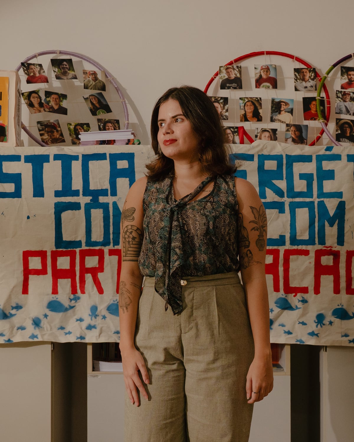 A young Latina woman in an office with a banner behind her
