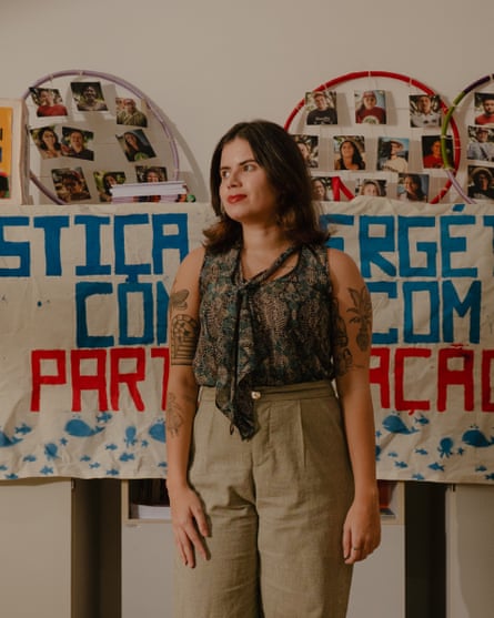 A young Latina woman in an office with a banner behind her