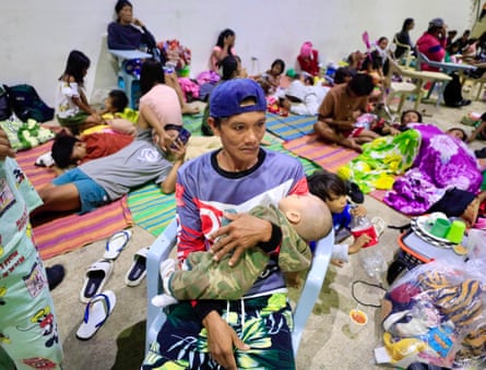 Villagers take shelter inside a gymnasium turned into a temporary evacuation centre in the coastal town of Aparri