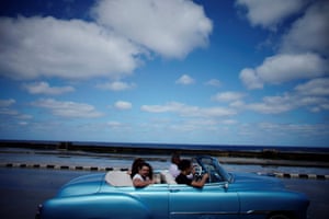 Tourists drive along the Malecón corniche in Havana, Cuba