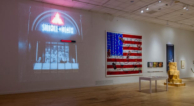 An installation view of Art Aids America with Act-Up’s Let the Record Show on the left.