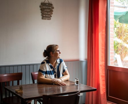 Nadine Letellier sitting at a cafe table looking out the window