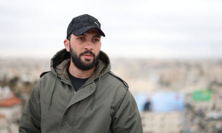A 22-year-old Palestinian man with a black beard wearing a baseball hat