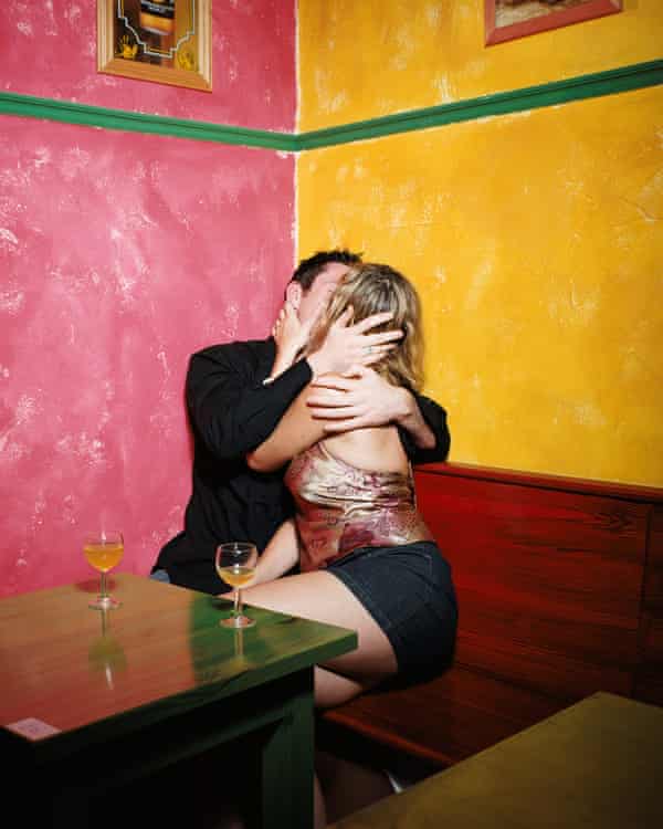 A couple kissing in the corner of bar (posed by models)