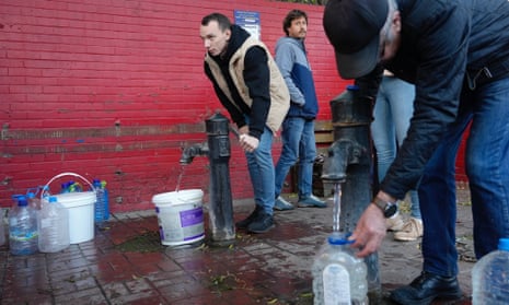 People fill containers with water from public water pumps in Kyiv, Ukraine on 31 October.