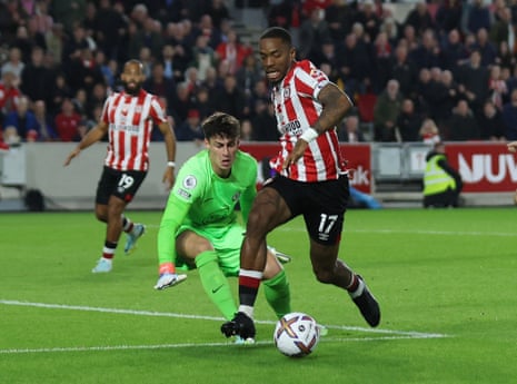 Brentford's Ivan Toney is shepherded away from the danger area by Chelsea's keeper Kepa Arrizabalaga.