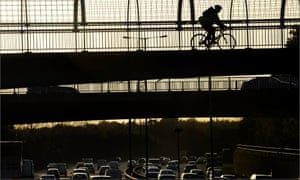 A cyclist crosses the M60 orbital motorway in Manchester.