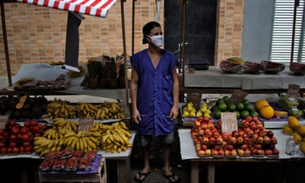 A fruit and vegetable seller waits for customers after street markets were reopened in Rio de Janeiro, Brazil, on 29 April 2020.