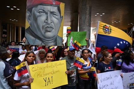 A corwd hold signs calling for a referendum and a giant portrait of a man in military uniform