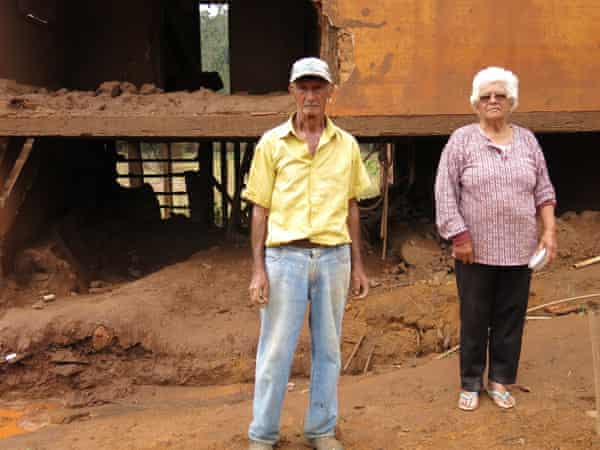 Geraldo Nascimento and Francisca da Silva stand in front of their ruined house.