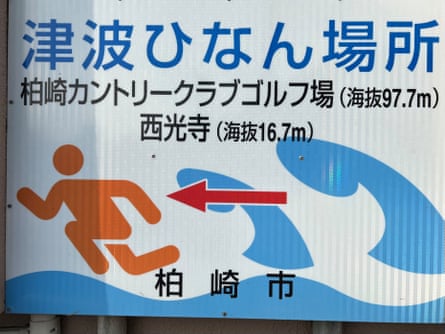A sign urges residents to evacuate to a nearby golf course or temple in the event of a tsunami.