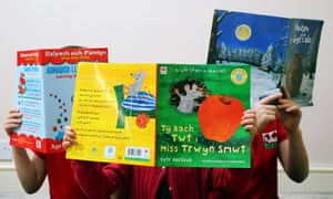Children holding up picture books in Welsh