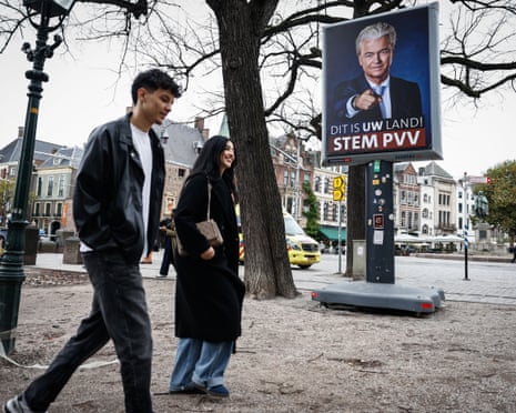 Pedestrians walk past an electoral poster of the president of the far-right Party for Freedom (PVV), Geert Wilders, in The Hague.