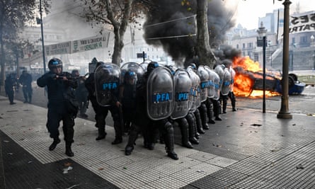 Riot police officers stand in position during clashes with demonstrators outside the National Congress in Buenos Aires.