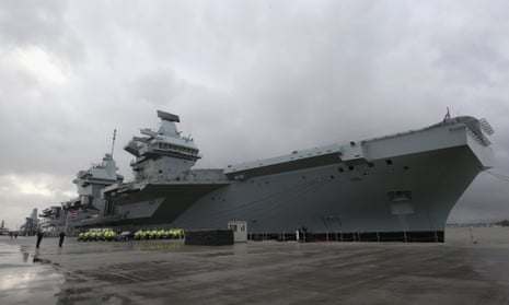 Police officers are seen in front of HMS Queen Elizabeth during the commissioning ceremony of HMS Queen Elizabeth at HM Naval Base.