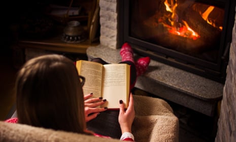 Woman reading a book by the fireplace