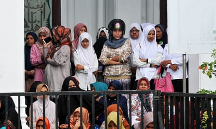 Acehnese women watch the flogging of ten people for violating Sharia law in Banda Aceh.