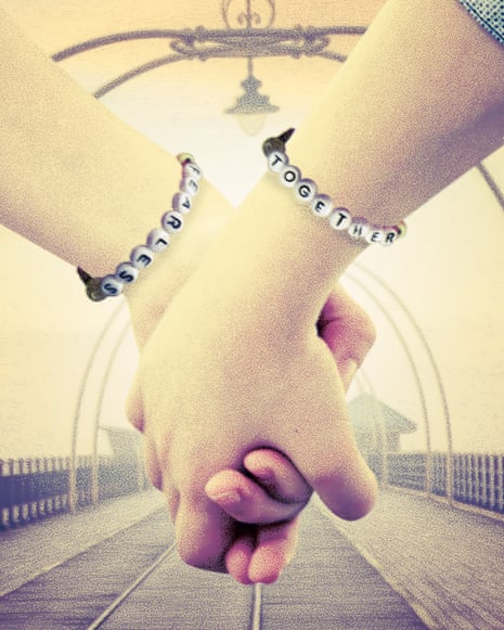 image of two girls' hands clasped together. They wear bracelets with letters on their wrists, reading 'fearless' and 'together'.