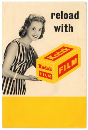 A smiling woman in a striped dress holding a giant roll of Kodak film