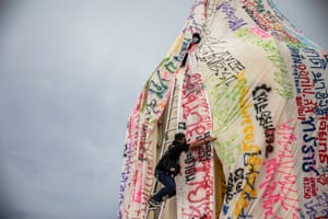 Demonstrators drape a sheet with anti-government messages over Bangkok’s democracy monument.