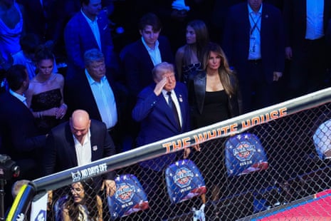 Donald Trump salutes to the crowd alongside his wife, Melania, and UFC CEO Dana White.