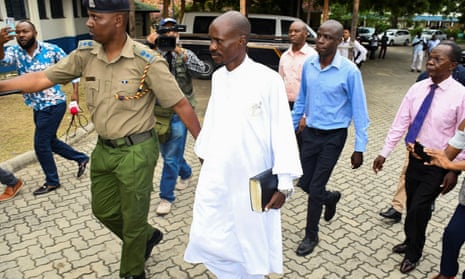 Detectives escort Ezekiel Odero outside the police headquarters in Mombasa.