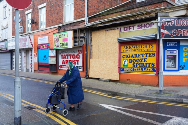 An elderly woman pushes her shopping trolley past boarded-up shops in the Fylde coast seaside resort, Blackpool