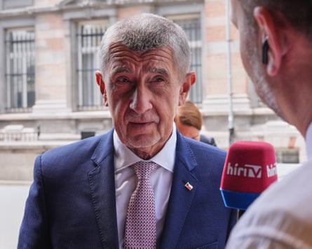 Andrej Babiš listens to a TV reporter speaking into a microphone