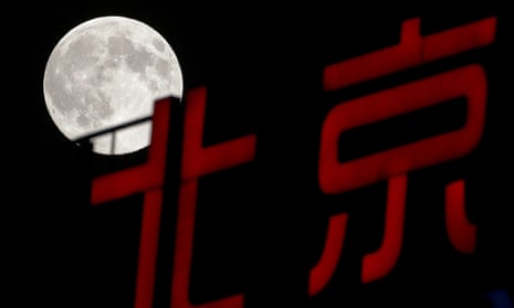 A super moon rises over Chinese calligraphy spelling out Beijing