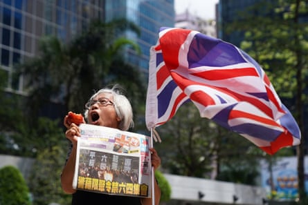 A supporter holds an apple and a copy of the Apple Daily newspaper outside the court to support Jimmy Lai in October 2019.