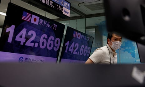 An employee of foreign exchange trading company Gaitame.com stands next to monitors displaying the Japanese yen exchange rate against the US dollar at its dealing room
