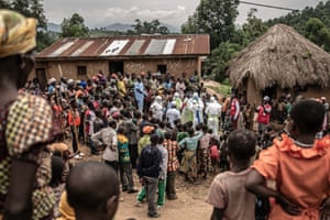 Neighbours and Red Cross burial workers in protective clothing gather outside the home of a family where an 11-month-old girl has died during Congo’s Ebola outbreak in the town of Rutshuru in North Kivu province, February 2020.