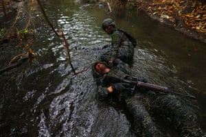 A trainee pulls a fellow trainee, who is pretending to be injured, through sewage contaminated water during the last week of a ten week programme to become members of the Taiwan navy’s elite Amphibious Reconnaissance and Patrol unit, at Zuoying navy base.